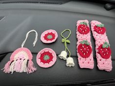 crocheted items are displayed on the dashboard of a car, including strawberries and pomegranates