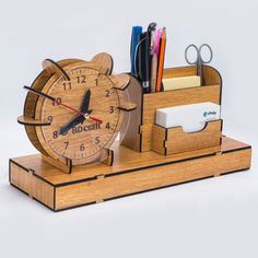 a wooden desk clock with pen and pencil holder on it's stand, which holds office supplies