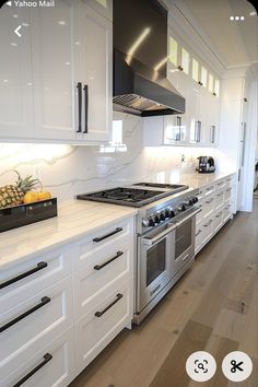 a kitchen with white cabinets and stainless steel appliances