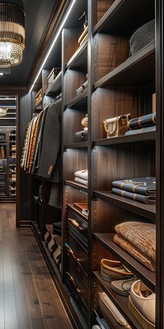 a walk in closet filled with lots of shoes and clothing on shelves next to a chandelier