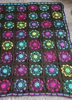 a crocheted blanket that is laying on the floor