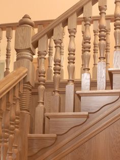 a wooden staircase with handrails and wood balconies in a home setting