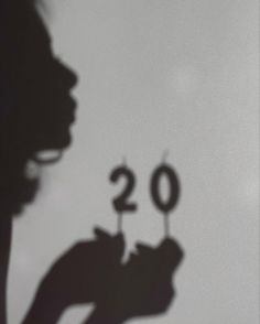 the shadow of a person holding a candle in front of a number twenty - two sign