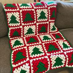 a crocheted christmas tree afghan sits on a couch