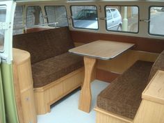 the inside of a bus with wooden seats and tables