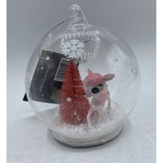 a glass snow globe with a little deer in it and a red christmas tree inside