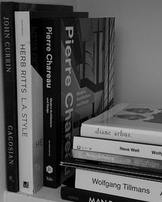 a stack of books sitting on top of a white shelf