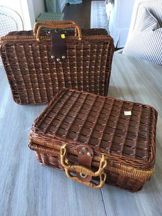 two brown wicker suitcases sitting on top of a wooden floor next to each other