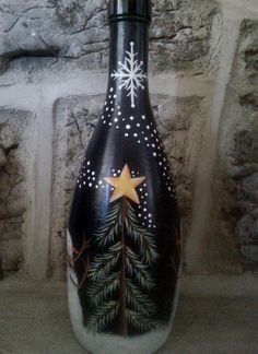 a black and white bottle with a gold star on it sitting in front of a stone wall