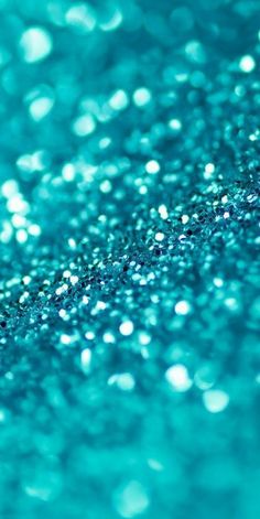 a close up view of blue glitter on a surface with lots of small bubbles in the background