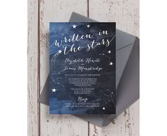 a wedding card with the words written in white ink and stars on it, sitting on top of an envelope