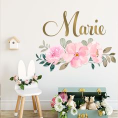 there is a wall with flowers on it and the name marie in gold lettering