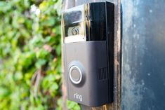 the ring video door phone is attached to a metal pole with ivys in the background