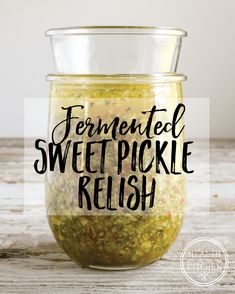 a jar filled with pickle relish sitting on top of a wooden table