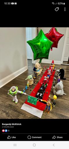 a group of toy characters on a red carpet with green and red balloons in the shape of stars