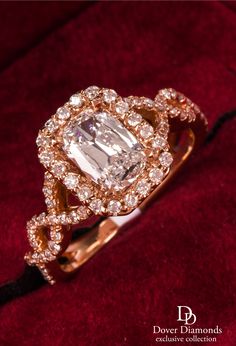 This stunning diamond ring is crafted in 18K rose gold. Displaying a prominent four prong set emerald cut diamond approx. 1.01 CT, D color, VS1 clarity. Surrounded by a halo of pave set round-cut diamonds, further embellished along a twisted shank weighing approx. 0.65carats, F-G color, VS2-SI1 clarity. Weighing 5.8 grams, measuring 21mm across the shoulders and 6mm high x 12mm wide. This shimmering engagement ring is a size 6.75. 14k Gold Vvs Clarity Halo Ring For Wedding, Luxury Yellow Gold Halo Ring With Vvs Clarity, Gold Halo Ring With Vvs Clarity, Luxury Gia Certified Yellow Gold Halo Ring, Gia Certified Yellow Gold Diamond Halo Ring, Gold Halo Engagement Ring, Stunning Diamond Rings, Ring Stand, Emerald Cut Diamond