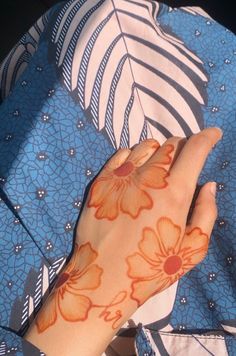 a woman's hand with orange flowers on it