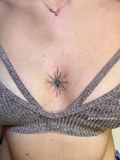 a woman's chest with a small star tattoo on her left side ribcage