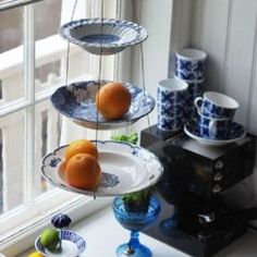 three tiered trays filled with fruit on top of a counter next to a window