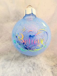 a blue ornament with believe written on it