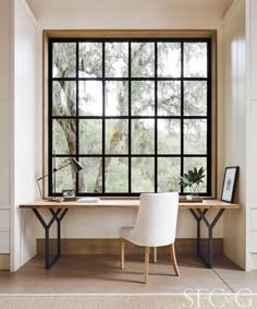 a desk with two chairs and a large window