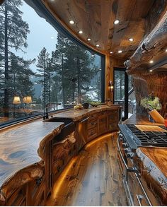 a large kitchen with wooden cabinets and an island in front of a window that looks out onto the woods