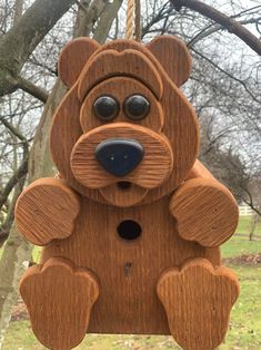 a wooden bear ornament hanging from a tree