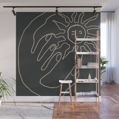 a wall mural in the living room with a hand drawn on it and shelves below