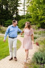 a man and woman walking down a path holding hands