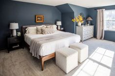 a bedroom with blue walls and white furniture