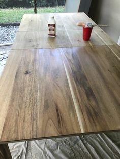 a table that has some kind of wood on top of it with a red cup next to it