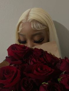 a woman hiding her face behind a bouquet of roses