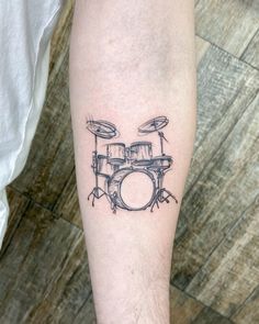 a black and white photo of a drummer's drum set tattoo on the leg