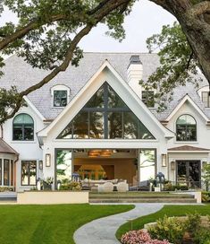 a large white house sitting on top of a lush green field