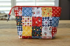 a colorful patchwork purse sitting on top of a wooden table