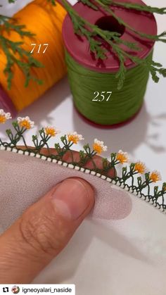 someone is stitching flowers on the side of a piece of fabric