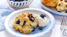 blueberry muffins with ice cream on a plate next to a bowl of fruit