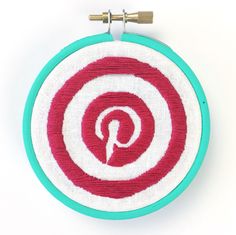 a red and white circle with the letter p on it is hanging from a hook