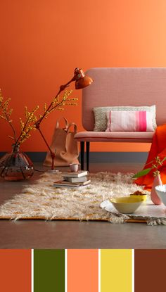 a living room with orange walls, white rugs and various items on the floor