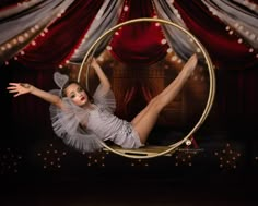 a woman is posing in a hoop with her legs spread out and hands behind her head