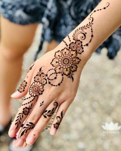 a woman's hand with henna tattoos on it