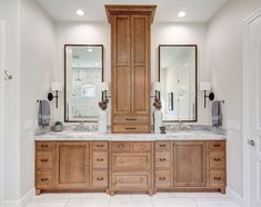 a large bathroom with double sinks and wooden cabinets