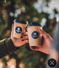 two people holding coffee cups in their hands