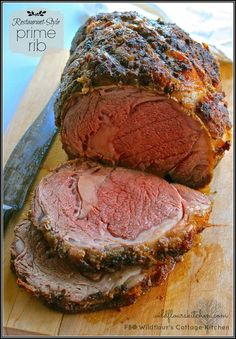 sliced meat on a cutting board next to a knife