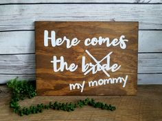 a wooden sign that says here comes the bride, my mommy with white lettering on it