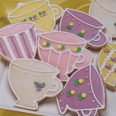 decorated sugar cookies in the shape of teacups and coffee cups on a plate