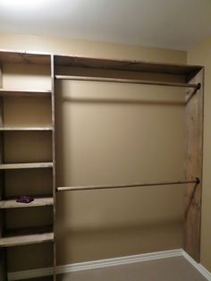 an empty walk in closet with shelves and no doors on the door, next to a carpeted floor