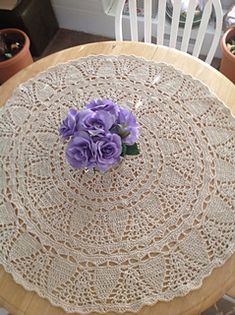 a doily with flowers on it sitting on top of a table