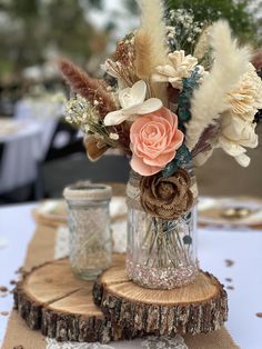 a vase filled with flowers sitting on top of a wooden tablecloth covered table cloth