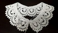 a white crocheted collar with a bow on it